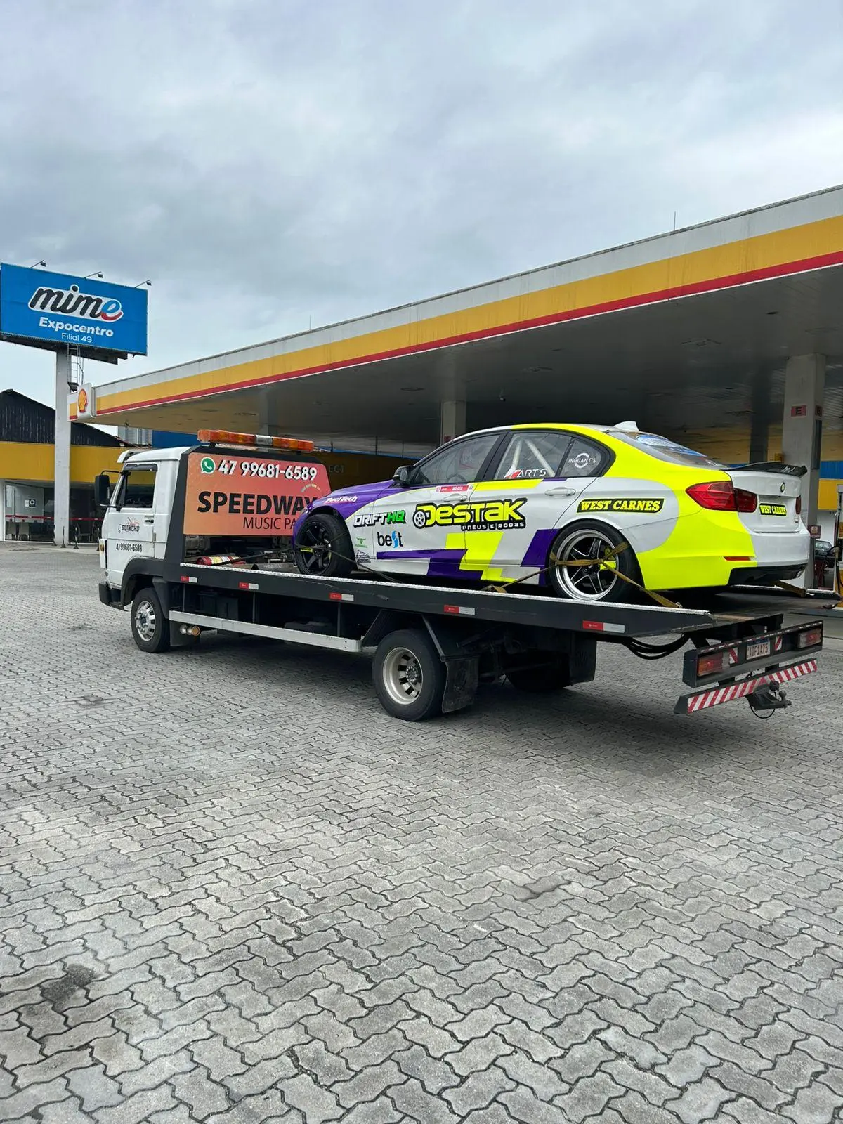Guincho SpeecBC em posto com carro de competição